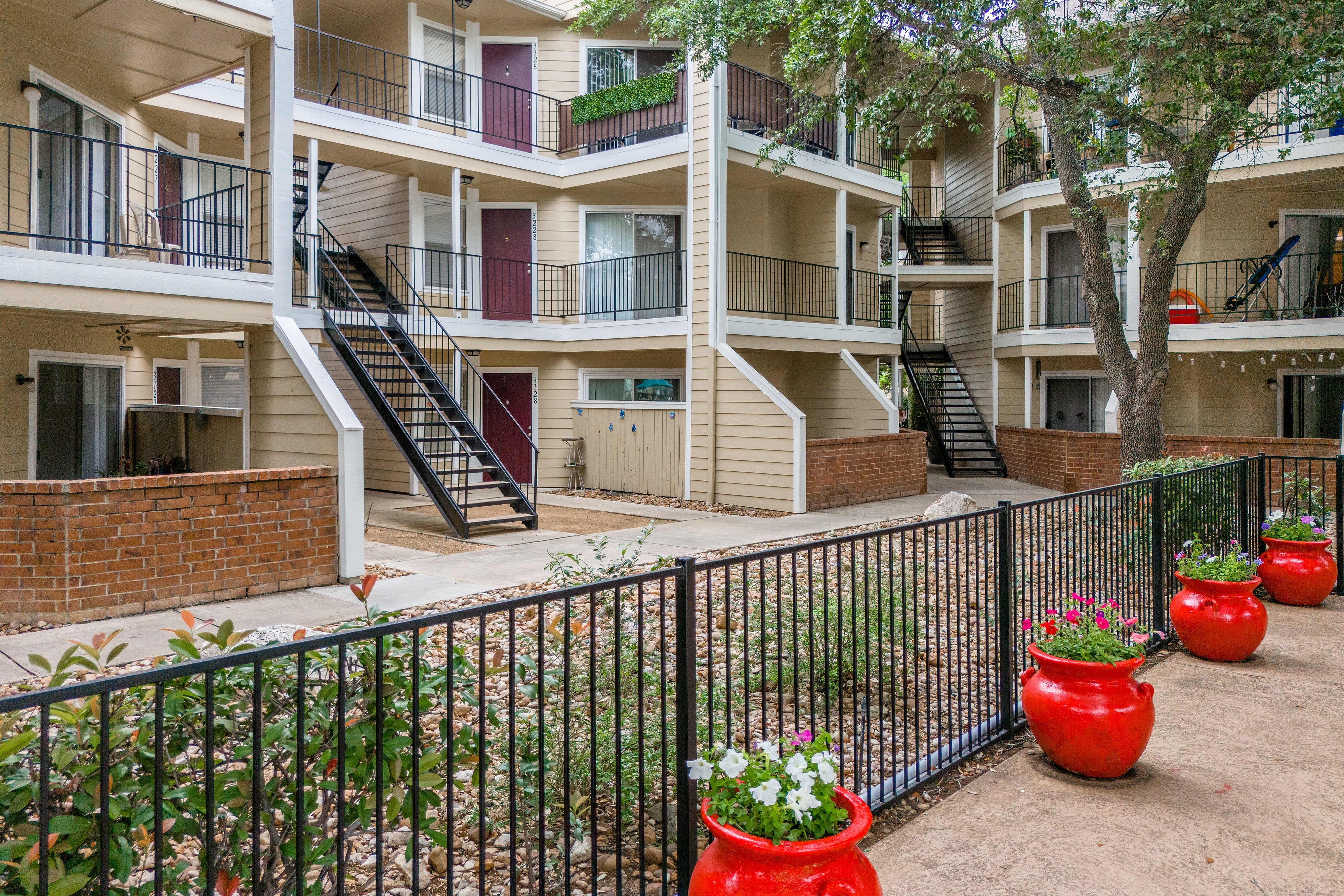 Apartment complex with red flower pots in front.